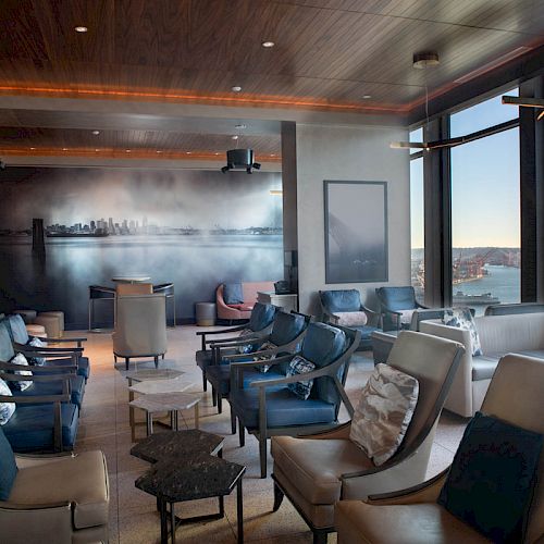 Elegant lounge with plush seating, large windows, scenic view, and ambient lighting, creating a cozy and inviting atmosphere.